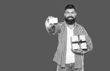 Olgun sakallı, hediye kutusu ve kartı olan bir adam. seçici odak.