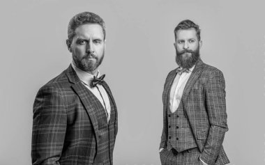 Formalite icabı smokin giyen adamlar. Smokinli adamlar resmi kıyafet giyerler. Papyonlu, erkek giyimli şık erkekler. İş etkinliğindeki iki iş adamı. Smokinli adamlar Griler 'de izole edilmiş. Akıllı erkek giyim..