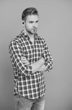 Kulaklık cihazı aksesuarı. Kablosuz kulaklık cihazı. Banliyö kulaklıkları. Aletli adam. Kablosuz kulaklıklı bir adam. Adam gri renkte izole edilmiş kulaklık kullanıyor. Modern kablosuz kulaklıklar. Elsiz kulaklık.