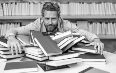 Bilgi günü. Öğretmen kitaplardan bilgi alır. Kitapçıdaki erkek öğretmen. Üniversite öğretmeni kitap okuyor. Bilgi başarının anahtarıdır. Kütüphanedeki öğretmen. Kitap seven adam eğitim alır..