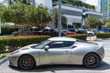 Miami, Florida, ABD - 07 Nisan 2025: 2011 Lotus Evora spor araba. Lüks spor araba Lotus Evora. Lotus Evora dışarıda park etmiş. Gümüş renkli mat araba, yan görüş..