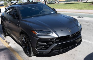 Miami, Florida, ABD - 02 Aralık 2024 Lamborghini Urus lüks SUV mat siyah araba. Lüks arazi aracı Lamborghini Urus. Araba siyah Lamborghini Urus dışarı park etmiş. Lamborghini Urus, köşe manzaralı..