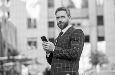 Sosyal ağ. Ofis binasında telefonu olan İspanyol bir iş adamı. Telefon kullanan bir iş adamı. Şehirdeki erkek telefon konuşmaları. İş adamı telefonda konuşuyor. İşadamı CEO ön ofiste..