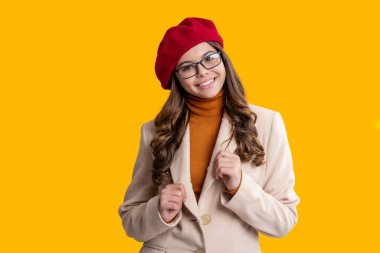 Mevsimlik moda tarzı. Şık bir sonbahar kızı sarıda izole edilmiş. Sonbahar beresi ve gözlük takan genç bir kız. Paltolu sonbahar kızı. Sonbahar ve sonbahar. Sonbahar sezonu. Sonbahar modası. Zeki ve şık..