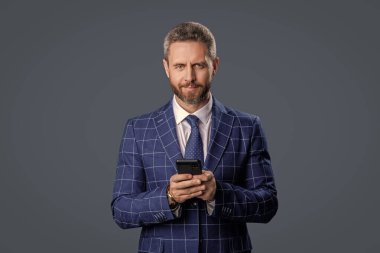 İş adamı sohbeti. İş adamı mesajlaşması ve mesajı. Sosyal ağ. Telefonu olan İspanyol bir iş adamı. Telefon kullanan bir iş adamı. Gri yolda insan telefonu görüşmesi izole edildi. Pazarlık taktikleri.