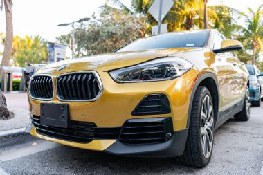Miami, Florida, ABD - 07 Nisan 2025: lüks BMW X2. BMW X2 otomobili dışarıda park halinde. Altın araba, ön manzara. 2018 BMW X2 geçiş aracı.