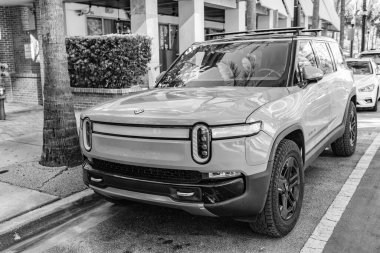 Miami Beach, Florida USA - 9 Haziran 2024 Rivian R1S Macera Motoru Miami plajında. Rivian R1S açık gri mavi