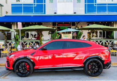 Miami, Florida, ABD - 4 Nisan 2025: lüks SUV Lamborghini Urus. Lamborghini Urus dışarıda park etmiş. Kırmızı araba, yan görüş. 2024 Lamborghini Urus lüks spor arazi aracı.