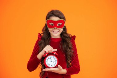 Geç kalan maskeli kız turuncu giyinmiş. Geç saatte. Parti geri sayımı. Parti maskeli, saati olan genç bir kız. Parti sonrası eve geç gelen bir kız. Tatil eğlencesi bitti. Geri sayım.