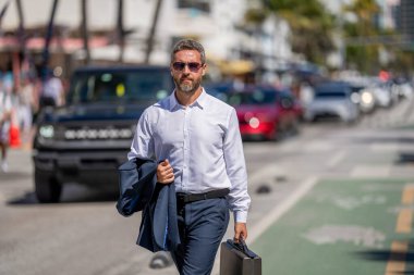 Başarılı bir iş adamı dışarıda evrak çantasıyla dolaşıyor. İş adamı evrak çantasını tutar. Başarılı bir anlaşmadan sonra bir iş adamı. Şirket işi. Takım elbiseli kendine güvenen bir iş adamı. İş Portresi.