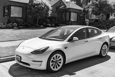 Seattle, WA, ABD - 3 Temmuz 2024: Tesla model 3 beyaz lüks evin yanında.