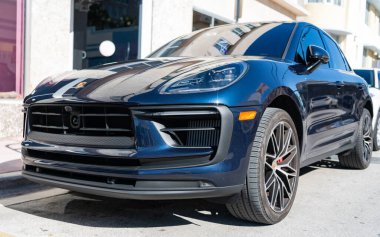 Miami, Florida, ABD - 21 Aralık 2024: Porsche Macan 2020 geçişi koyu mavi araba. Lüks araba Porsche Macan. Araba siyah renkli Porsche Macan dışarıda park etmiş. Porsche Macan, köşe görünümü.