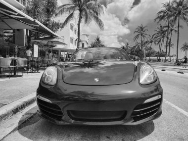 Miami Beach, Florida USA - 8 Haziran 2024: 2018 Porsche 718 Boxter mavisi Miami sahilinde. Ocean 'daki lüks araba porshche' si Miami plajına gidiyor. ön görünüm