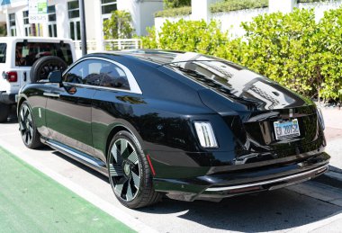 Miami, Florida, ABD - 12 Nisan 2025: Car Rolls Royce Spectre açık havada park etti. Siyah elektrikli araba, köşe manzaralı. 2024 Rolls Royce Spectre coupe elektrikli Grand Tourer. Elektrikli araba Rolls Royce Spectre.