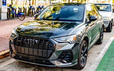 Miami, Florida, ABD - 07 Nisan 2025: Audi Q3 numaralı araba açık havada park edilmiş. Koyu yeşil kesişen araba, köşe manzaralı. 2025 Audi Q3 hibrit coupe crossover araba. Coupe crossover araba Audi Q3.