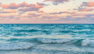 Deniz ufkuyla gökyüzü. Deniz doğarken sakin ufuk manzarası. Deniz manzarasında romantik yaz tatili gündoğumu. Deniz ufku manzarası. Yaz tatilinde bulutlu gökyüzü ve deniz manzarası. Deniz dalgaları.