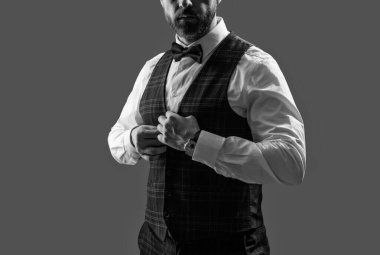 Damadın smokin tarzı var. Centilmen smokini. Smokin giysisi çıkarıldı. Papyonlu adam gride izole edilmiş. Zarif siyah takım elbiseli şık bir adam. Smokinli bir beyefendi. Resmi etkinlikteki iş adamı. Zarif uşak..