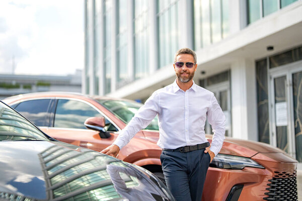 Mature businessman. Rich business man expressing success. Luxury business. Rich man near expensive car. Luxury business travel. Confident businessman in classic suit standing at parking, copy space.