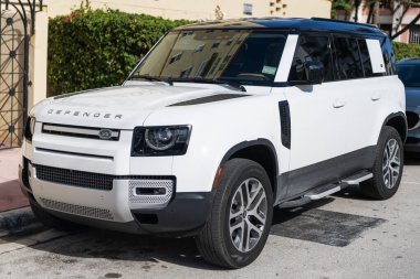 Miami, Florida, ABD - 17 Aralık 2024: 2025 Land Rover Defender SUV beyaz araba. Lüks arazi aracı Land Rover Defender. Açık havada park edilmiş beyaz Land Rover Defender arabası. Land Rover Defender, köşe görünümü.