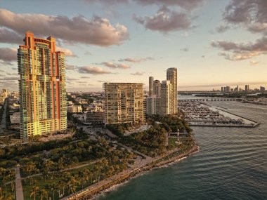 Akşam günbatımında şehir silüeti. Liman kenti havası. Miami Güney Sahili. Gün batımında gökdelen şehir manzarasında havadan panoramik manzara. Günbatımı şehir havası. Miami, Florida 'da lüks bir gökdelen.