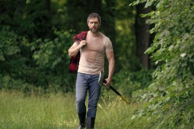 Ormanda baltayla oduncu. Keresteci gömlekli ve baltası ağır. Ormanda güçlü bir adam. Oduncu ormanda balta taşıyor. Oduncu çok çalıştıktan sonra terliyor. Baltalı olgun bir adam..