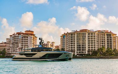 Fisher Adası Binası. Lüks motorlu tekne yatı. Yat marinaya gidiyor. Tekne ve yat gezisi. Lüks bir yaşam tarzı. Fisher Adası 'nda lüks bir binada yat. Yaz tatili. Romantik gün batımı.