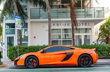 Miami, Florida, ABD - 07 Nisan 2025: Turuncu spor yara izi, yan görüş. McLaren 650S 2015 spor araba. Lüks spor araba McLaren 650S. Araba McLaren 650S dışarıda park halinde..