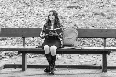 Eğitim ve bilgi. Bilgi toplama günü. Kendi kendine eğitim. Sonbahar kitabı. Okula dönelim. Okul eğitimi. Dışarıda kitap okuyan liseli kız. Genç kız sonbahar parkında kitap okuyor. Edebiyat.