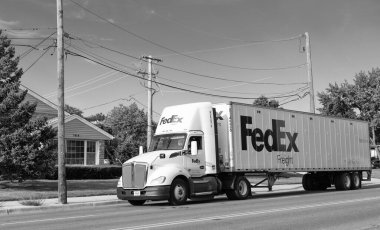 Chicago, ABD - 21 Ağustos 2024: Yolda FedEx konteynırlı kamyon. FedEx Şirketi, uluslararası kapsamı olan ABD merkezli bir lojistik şirketi. Federal Express teslimat işinde lider şirkettir..