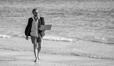 Uzaktan kumandalı iş adamı dizüstü bilgisayarda çalışıyor, kopyalama uzayı. Hafta sonu ve iş adamının uzaktan bağımsız çalışması. Uzak bir yaz çalışması. Serbest konsept ve yaz seyahati. İş adamı yaz tatili.