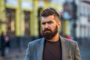 Sıradan bir iş tarzında şık ve vahşi bir adam. Sakallı işadamı. Sokak tarzı giyinen sakallı adam. Şehirdeki iş adamı. Şehir sokağında iş adamıyla. Erkek tarzı. Yüz resmi.