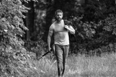 Baltalı yakışıklı bir adam. Ormanda baltayla oduncu. Keresteci gömlekli ve baltası ağır. Güçlü adam ormanda çalışır. Oduncu ormanda balta taşıyor. Oduncu çok çalıştıktan sonra terliyor.