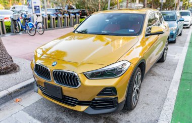 Miami, Florida, ABD - 07 Nisan 2025: lüks BMW X2. BMW X2 otomobili dışarıda park halinde. Altın araba, ön manzara. 2018 BMW X2 geçiş aracı.