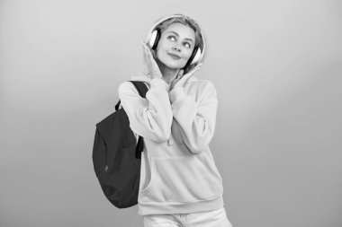 Genç bir kız mavi üzerine izole edilmiş. 1 Eylül. Üniversitede eğitim. Öğrenci kız okul çantasını tutuyor. Okula dönelim. Bilgi toplama günü. Bilgi ve eğitim. Öğrenci hayatı. Müzik dinle..