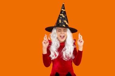 Tüm Cadılar Bayramı cadıları. Cadılar Bayramı cadı kostümüyle dilek tutan bir kız. Mutlu Cadılar Bayramı dilekleri. Cadılar Bayramı kostümlü cadı kız turuncu üzerine izole edilmiş. Şeker mi şaka mı? Tüm Cadılar Bayramı kostüm partisi kutlaması.
