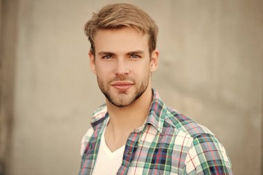 Sıradan tişörtlü bir adamın portresi. Tıraşsız adamın şık bir portresi. Dışarıdaki yakışıklı genç adam. Kareli gömlek giyen milenyum adamı. Milenyum erkeğinin gündelik tarzı.