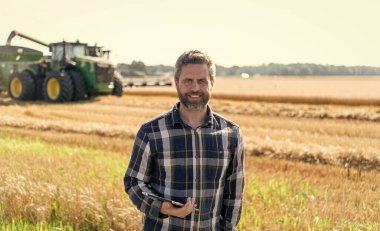 Tablet çekli İspanyol çiftçi. Ekin hasadı. Tarlada tableti olan çiftçi tarımcı adam. Modern tarımın teknolojisi. Tarlada tabletle çalışan çiftçi. Yenilik alanı.