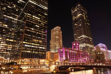 Gökdelen şehir manzarası. Chicago 'nun gece şehri. İş şehri. Chicago gökdelen binasının gece manzarası. Chicago gökdelenin mimarisi. Şehir gecesi aydınlatılmış bina. Gece enerjisi.