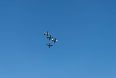 Askeri hava kuvvetleri savaş uçağı mavi gökyüzüne karşı tam gaz uçuyor. Gökyüzünde V şeklinde dört savaş uçağı. Filo. Hava Kuvvetleri Günü. Uçak filosu görev başında. ABD Hava Kuvvetleri.