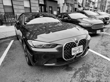 New York City, ABD - 10 Mart 2024: BMW 4 üstü açık lüks araba park yeri, ön manzara.