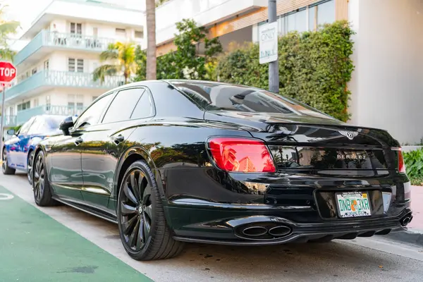Miami, Florida, ABD - 17 Nisan 2025: 2022 Bentley Flying Spur W12 sedan araba. Lüks araba Bentley Uçan Mahmuz W12. Araba Bentley Uçan Mahmuz W12 dışarıda park halinde. Siyah araba, yan köşe manzaralı..