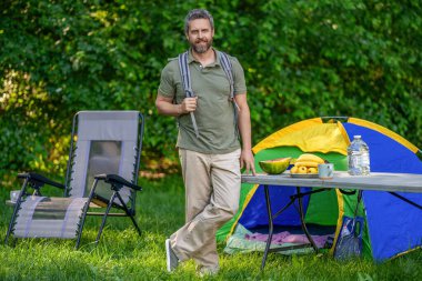 Piknik zamanı. Ormanda çadırlı piknik yapan bir adam. Yaz günü yürüyüş yapan bir adam. Yaz kampı aktivitesi. Yaz kampı. Kamp macerası. Yürüyüş yaşam tarzı. Kamp alanındaki adam. Yürüyüş molası.