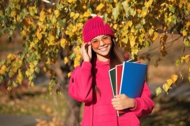 Bilgi ve eğitim. Okul bilgisi. Okula dönüyorum. Sonbahar kızı okul ödevini tutuyor. Ergenlik bilgisi. Sonbahar parkındaki genç kız. Sonbahar ders çalışma zamanıdır. Yüksek öğrenim.