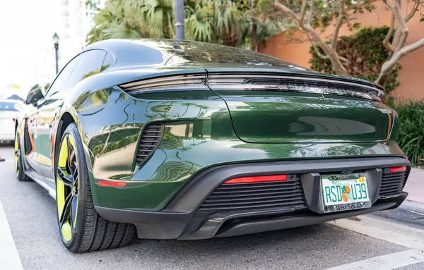 Miami, Florida, ABD - Nisan 06, 2025 Porsche Taycan Turbo S elektrikli spor araba. Elektrikli spor araba Porsche Taycan. Porsche Taycan dışarıda park etmiş. Yeşil elektrikli araba, arka plan..