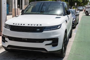 Miami, Florida, ABD - 21 Nisan 2025: 2025 Land Rover Range Sport lüks SUV arabası. Lüks arazi aracı Range Rover. Otomobil Range Rover 'ı dışarıda park etmiş. Beyaz SUV arabası, ön köşe manzaralı..