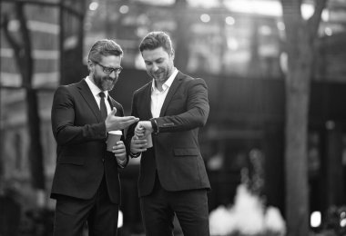 İş adamları zamanı kahve fincanıyla kontrol ediyor. İş arkadaşının iş görüşmesi var. İş adamlarının işi. Kahve molası. Dışarıdaki iş adamları. Kahve molasındaki iş arkadaşım. Dakiklik.