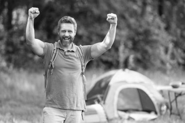 Yaz kampındaki adam. Kamp macerası. Yürüyüş konsepti. Kamp çadırı. Ormanda çadırda çadırda bir adam var. Bir yaz günü doğa yürüyüşçüsü. Yaz kampı ve mutlu doğa tatili.