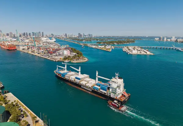Miami, Florida, ABD - 20 Mart 2025: Kargo gemisi. Miami liman lojistiği. Monrovia konteynırı gemisi. Kargo Seaboard Explorer konteynır gemisi, hava manzaralı. Yük konteynırı kargo gemisi ve römorkör..