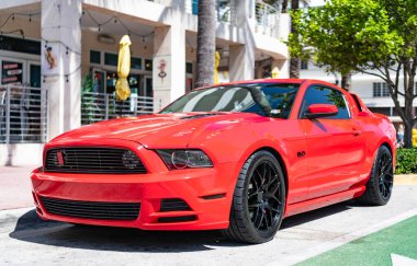 Miami, Florida, ABD - 12 Nisan 2025: 2014 Ford Mustang GT spor arabası. Lüks spor araba Ford Mustang GT. Araba Ford Mustang GT dışarıda park halinde. Kırmızı spor araba, köşe manzaralı.