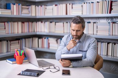 Üniversite öğretmeni. Öğretmenim sınıfta. Erkek öğretmen işyerinde ders çalışıyor. Üniversite sınavı öğretmenleri. Okul dersinde erkek öğretmen. Eğitimli insan bilgisi. Okumaya dalmış..